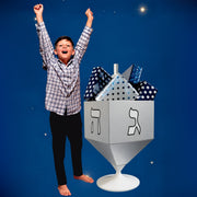 Child celebrating beside the Dreidel Cradle filled with Hanukkah gifts