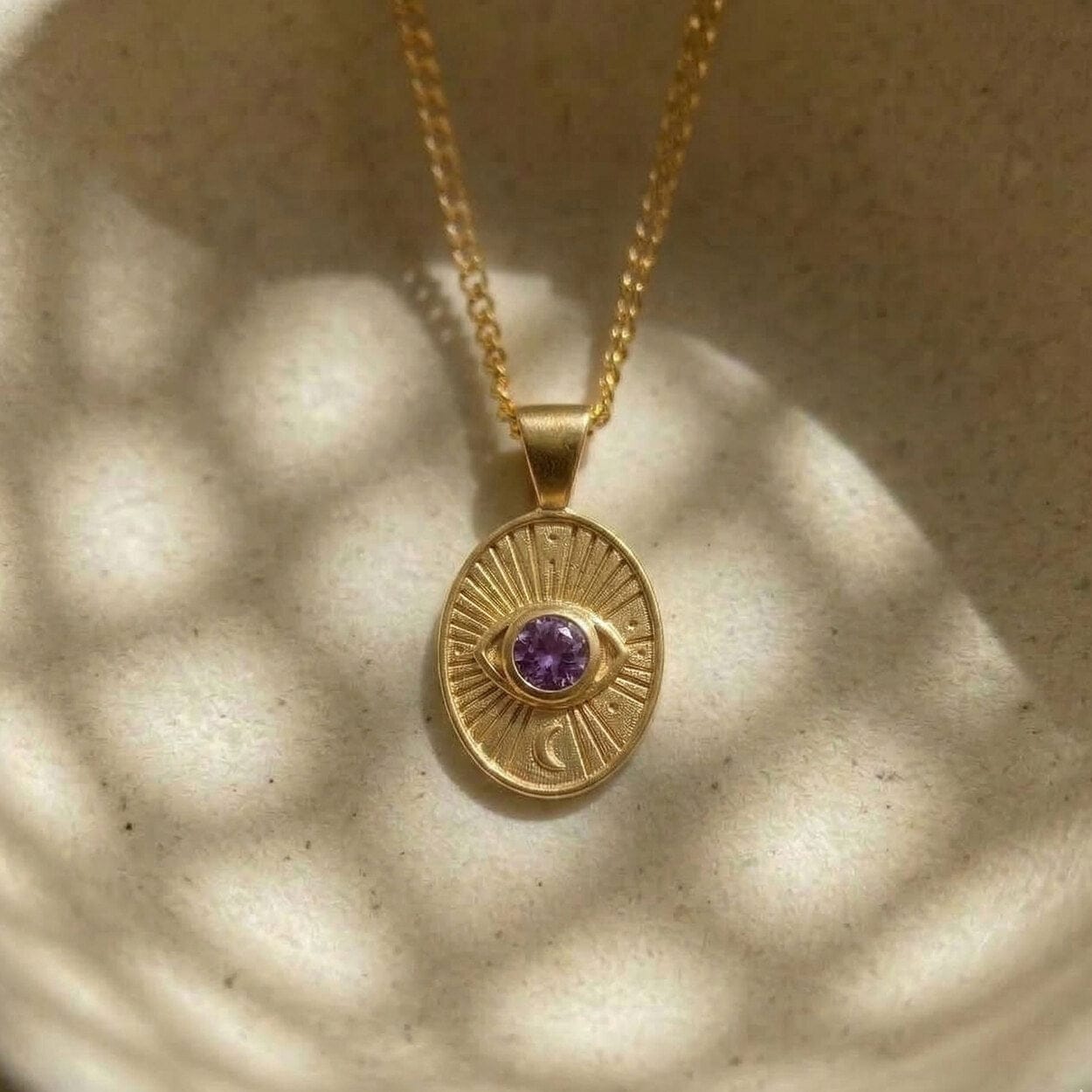 Divine Eye pendant detail showing the purple sapphire