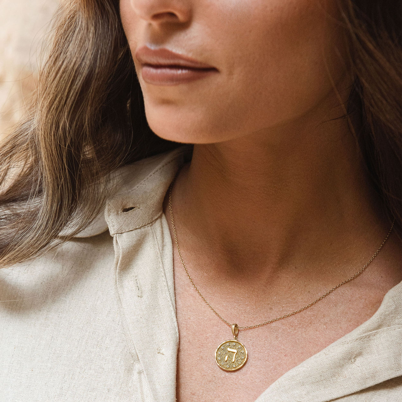 Letters of Light Hey pendant in 14k gold by Sages & Souls, worn