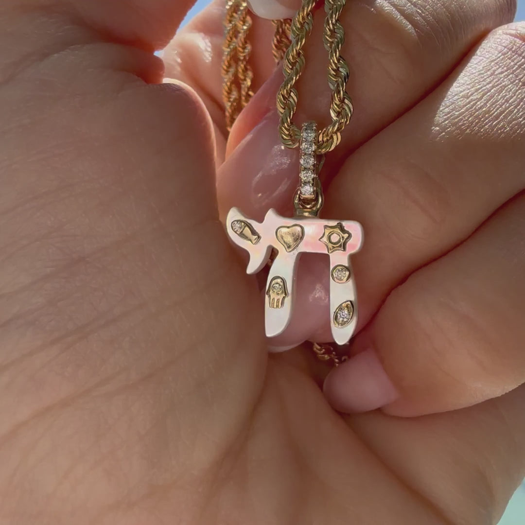 Jewish Charms Chai Gemstone Pendant held in hand on a gold chain