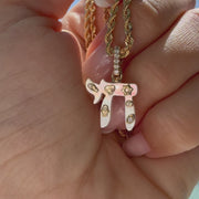 Jewish Charms Chai Gemstone Pendant held in hand on a gold chain