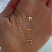 Hebrew Chai gold necklace shown on a hand in three sizes