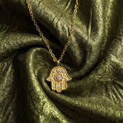Radiant Anchor Hamsa necklace styled on silk