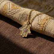 Radiant Anchor Hamsa necklace on textile