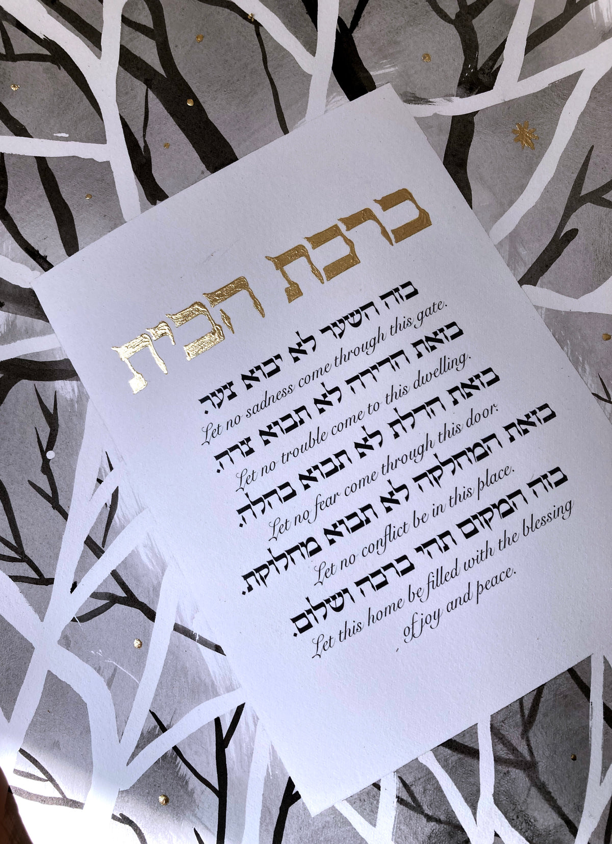 Close detail of the gold-leaf Hebrew title and hand-inked branches